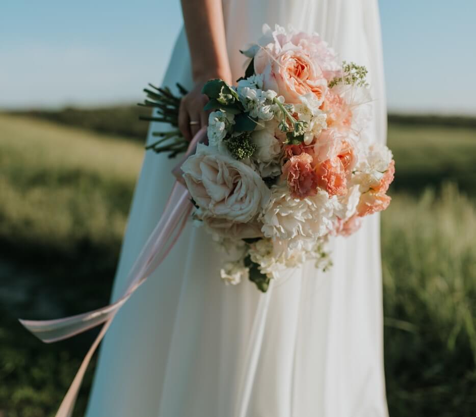 Bride wearing a white gown holding a flower bouquet