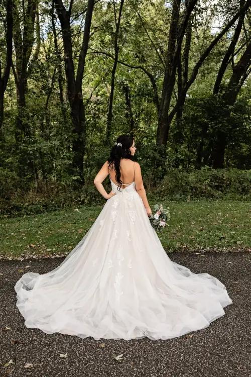 Bride posing for a picture, displaying back of wedding dress