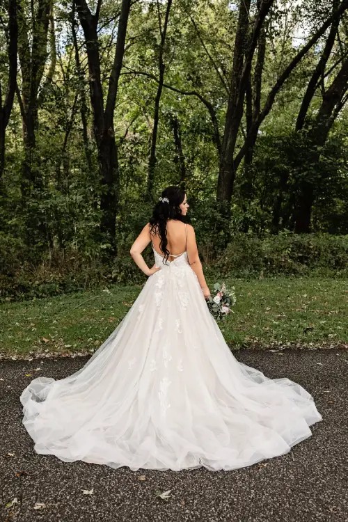 Bride posing for a picture, displaying back of wedding dress